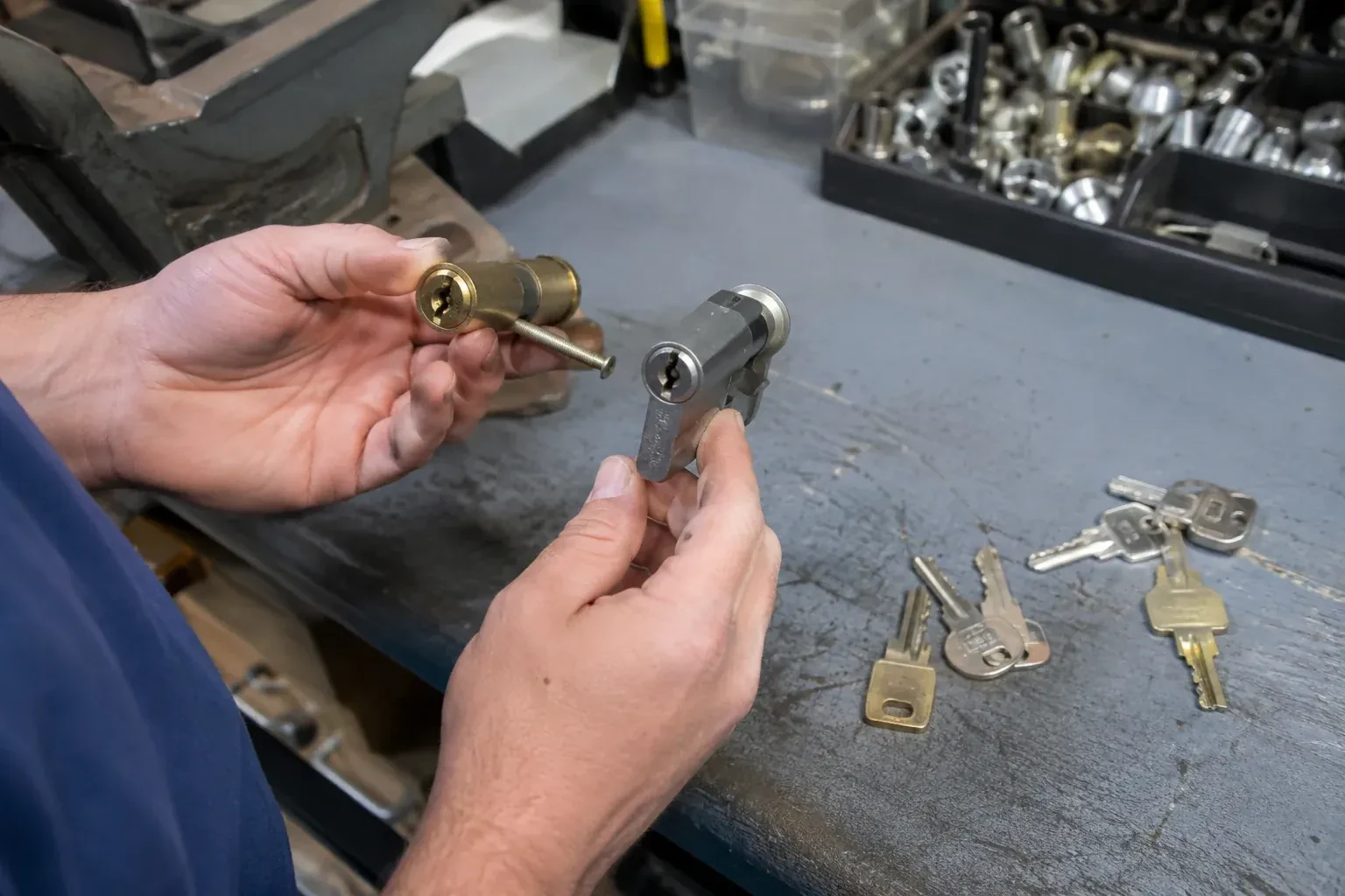 Hands comparing detached lock cylinders beside loose keys on a workbench. — Broken Key Extraction, Niagara Falls
